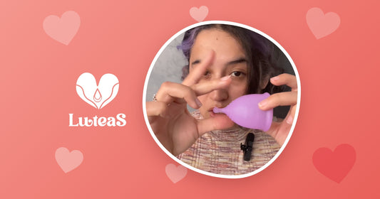 Persona sosteniendo una copa menstrual morada, guía Luteas